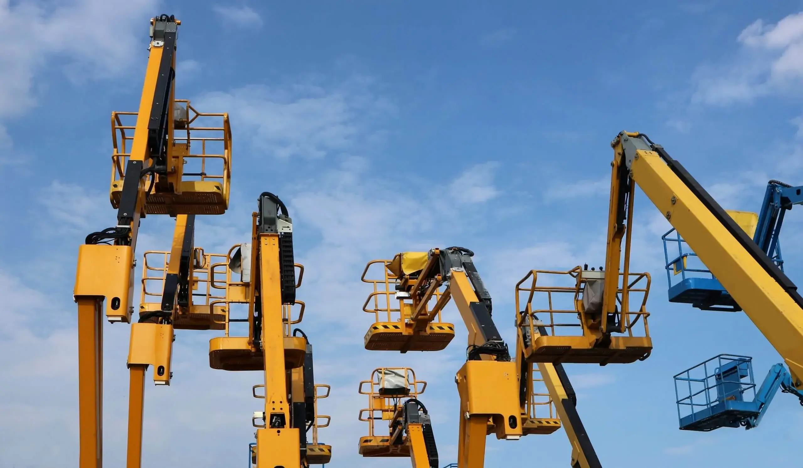 Aerial work  platform of cherry pickers on blue cloudy sky  background .